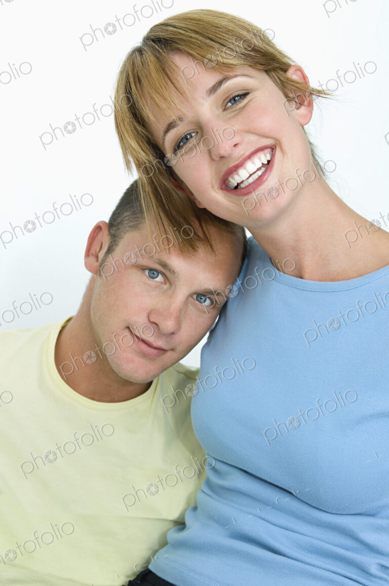 Woman and man smiling at camera with white background.