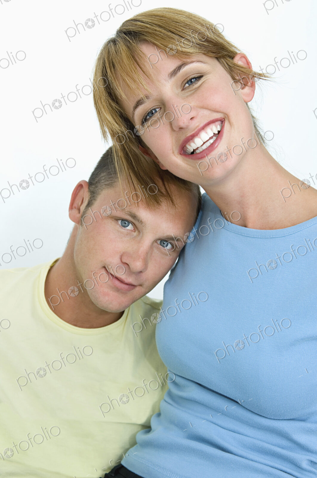 Woman and man smiling at camera with white background.