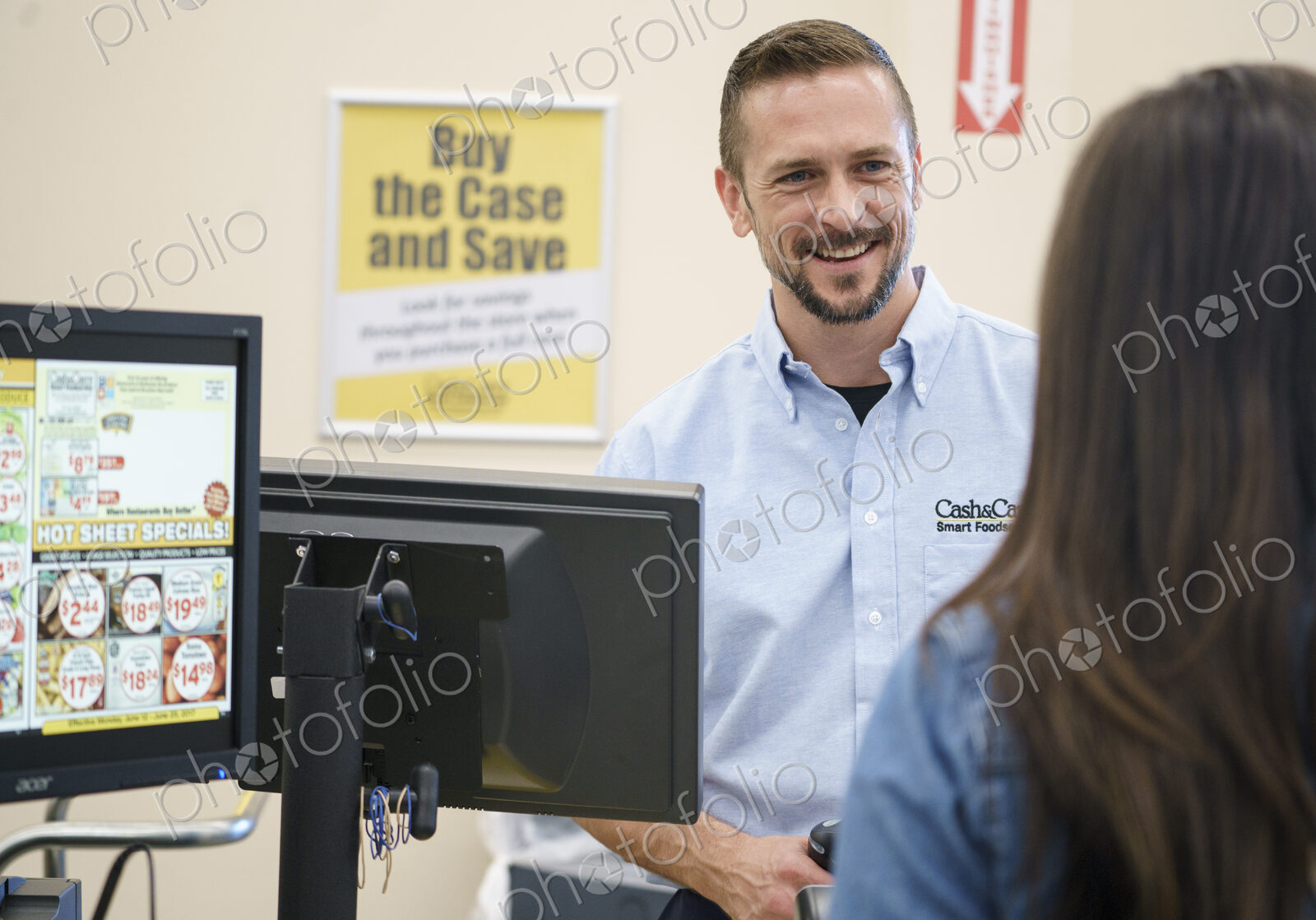 Woman at a till with retail assistant in a shop.