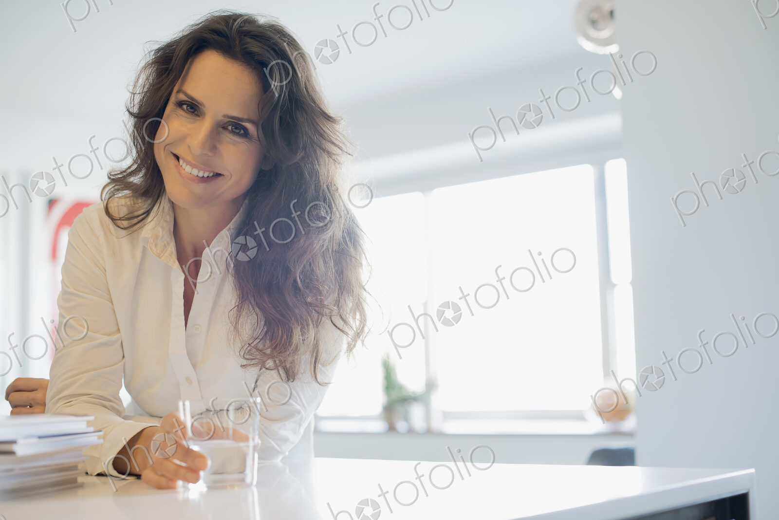 Woman at home in kitchen with glass of water