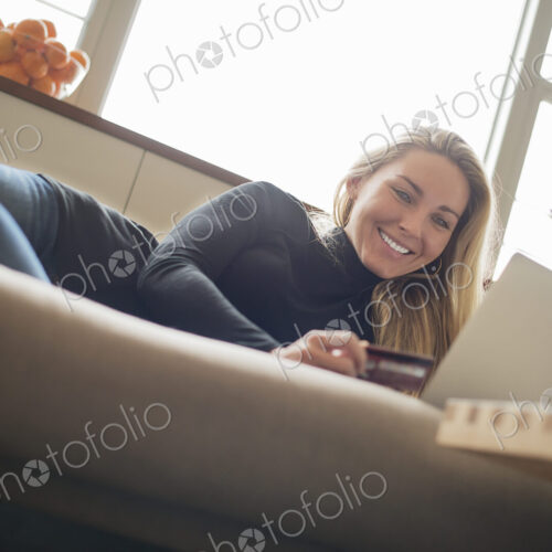 Woman at home, on-line shopping on sofa Woman at home, on-line shopping on sofa