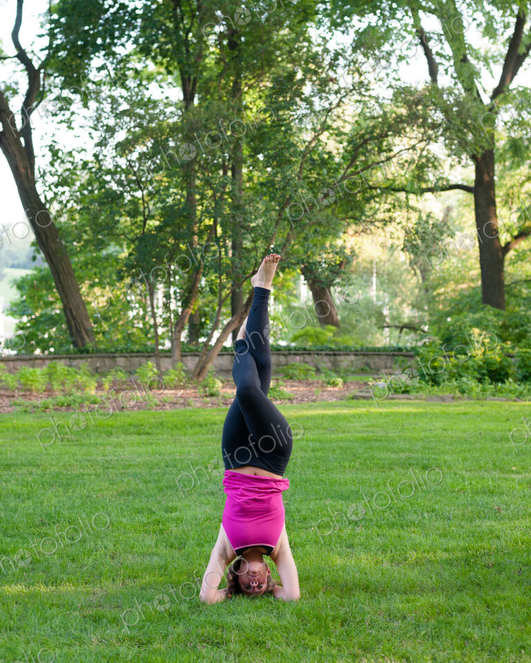 Woman balancing in yoga pose in park.