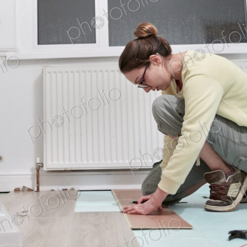 Woman fitting new floor board Woman fitting new floor board