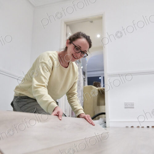 Woman fitting new wooden floor board