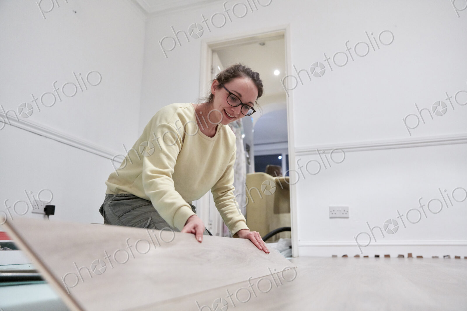 Woman fitting new wooden floor board