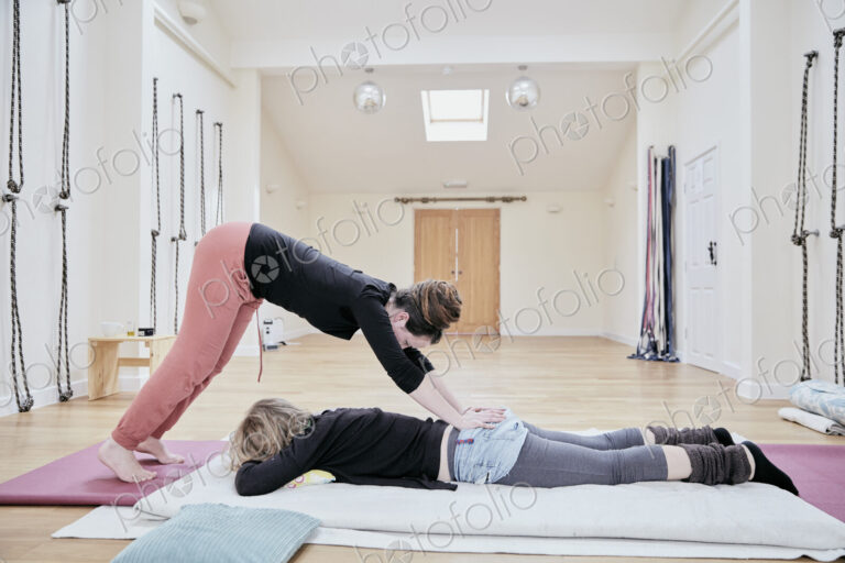 Woman having a Thai massage from a masseur.