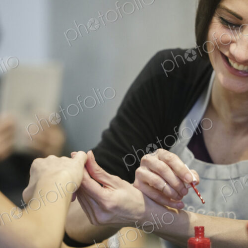 Woman having her nails painted in a nail salon. Woman having her nails painted in a nail salon.