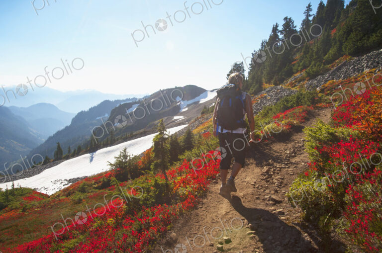 Woman hiking on rocky trail on remote hillside