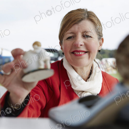 Woman holding a vintage porcelain figurine at flea market.