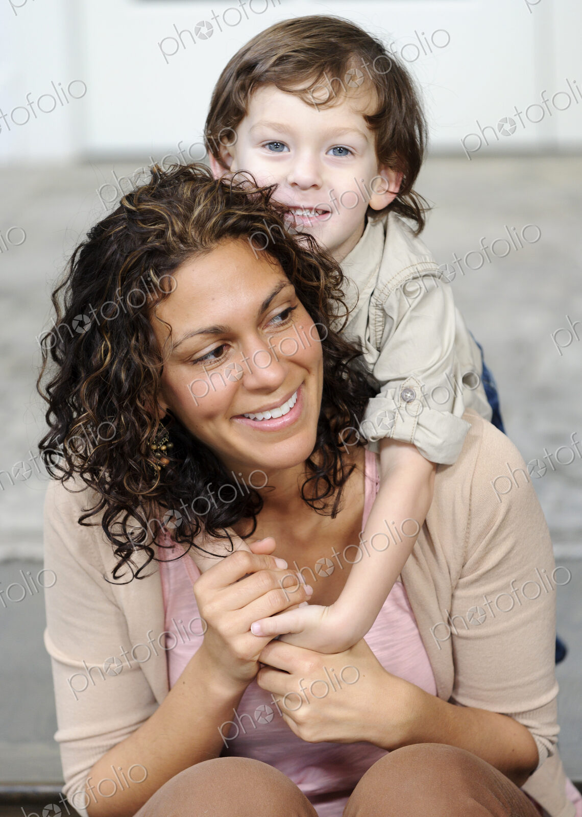 Woman hugging a boy, mother and sun laughing.