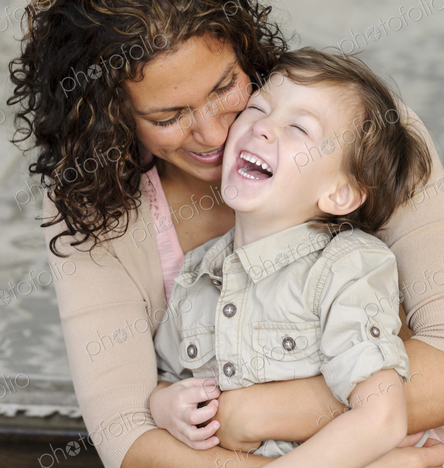 Woman hugging a boy, mother and sun laughing.