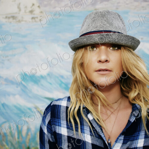 Woman in a blue checkered shirt and grey Trilby hat, looking at camera. Woman in a blue checkered shirt and grey Trilby hat, looking at camera.