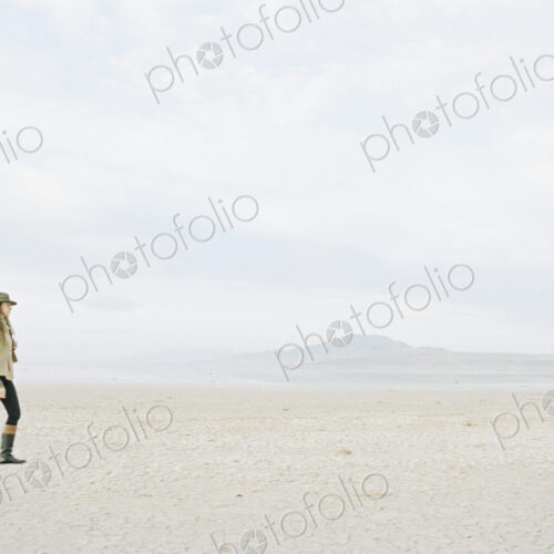 Woman in a hat and leather boots walking in the desert