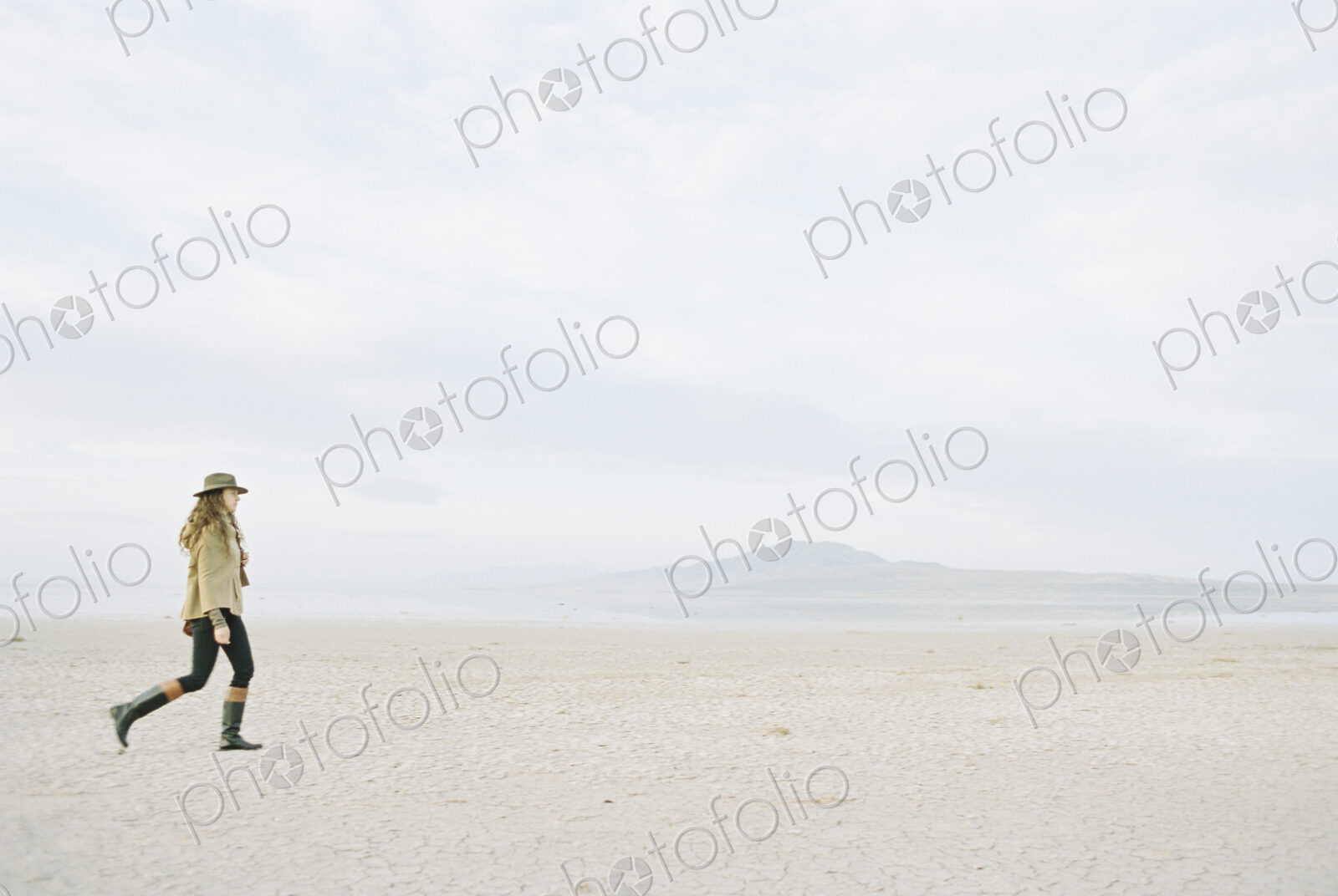 Woman in a hat and leather boots walking in the desert