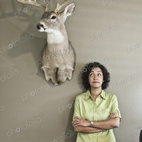 Woman in an office with a mounted deer head. Woman in an office with a mounted deer head.