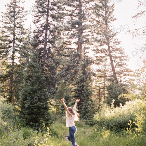 Woman jumping with joy in a sunlit forest. Woman jumping with joy in a sunlit forest.