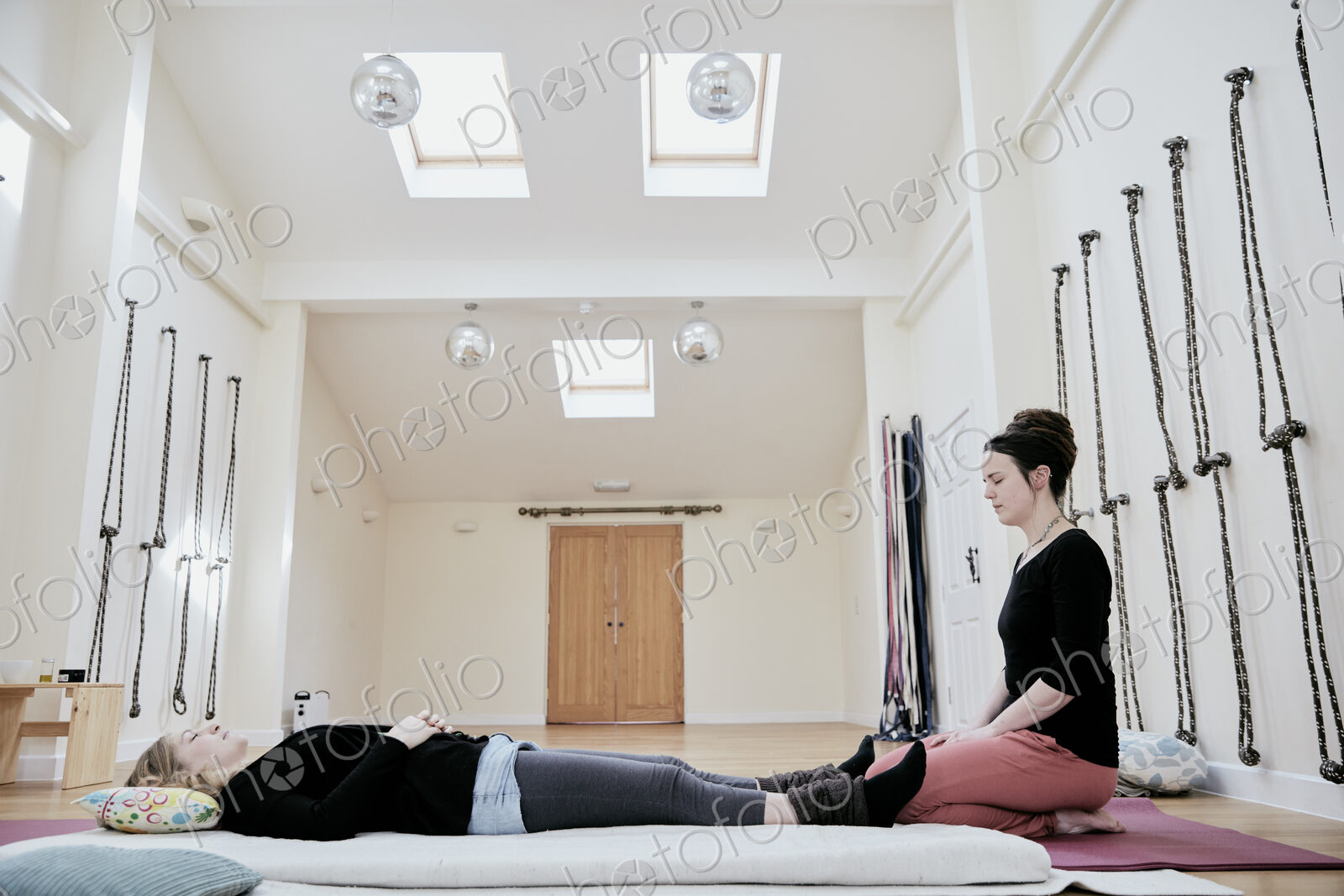 Woman lying down on her back fully clothed in preparation for a Thai massage