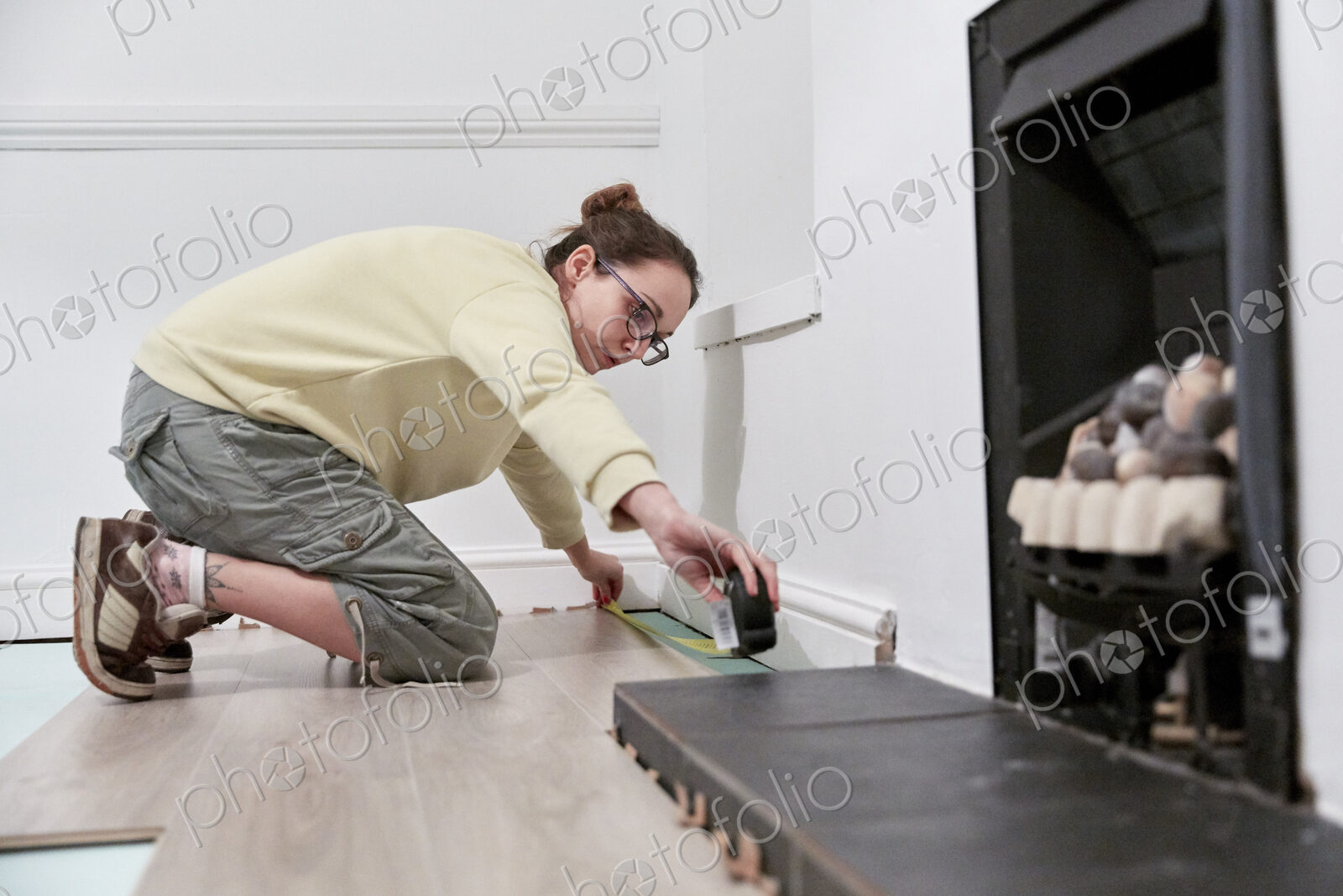 Woman measuring space fit new floor boards