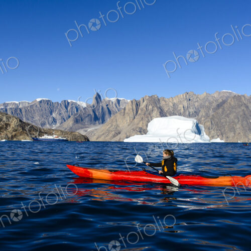 Woman paddling canoe near glaciers in remote river Woman paddling canoe near glaciers in remote river