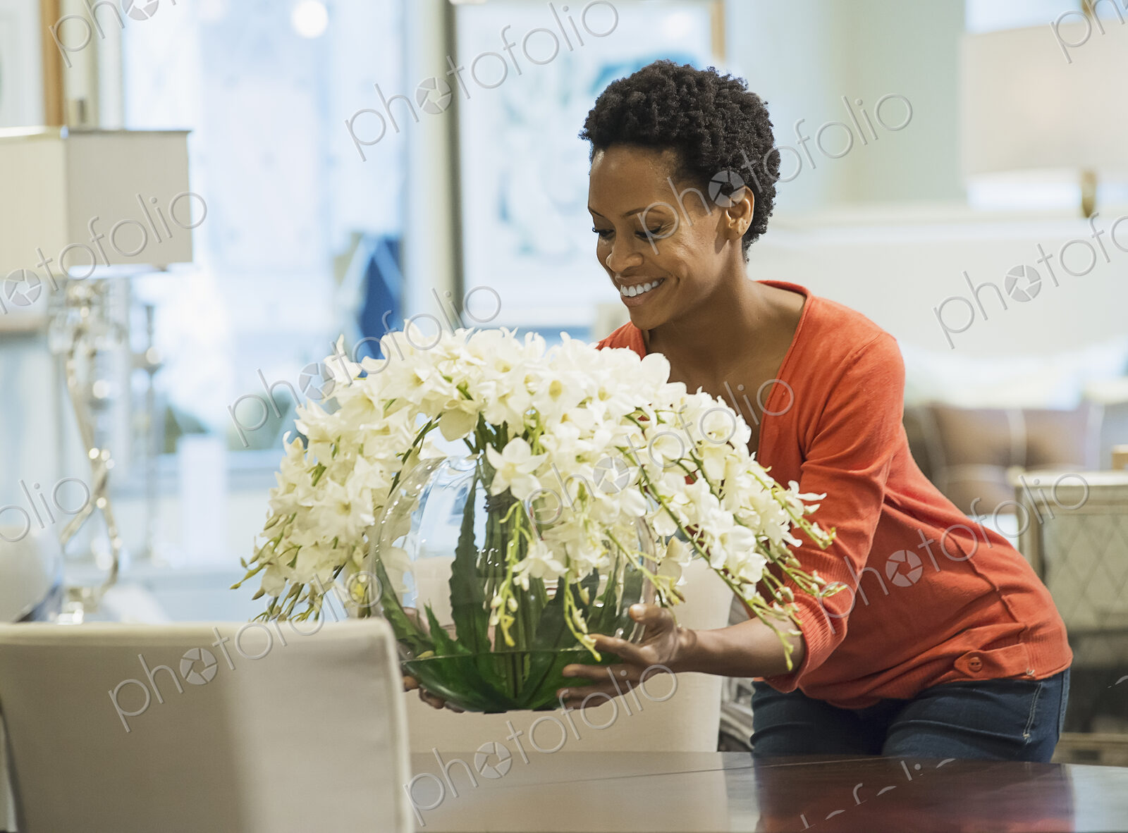 Woman placing vase of flowers on table