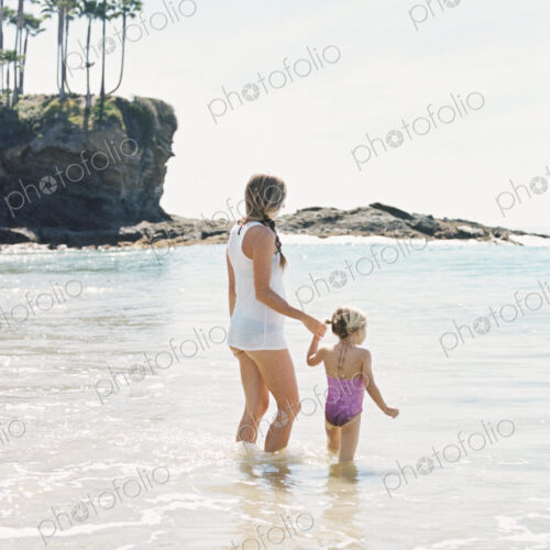 Woman playing with her daughter on the beach.