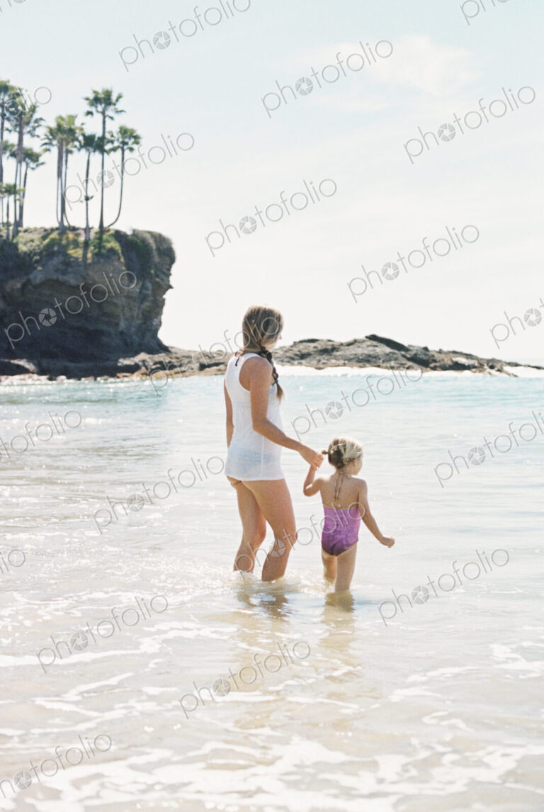 Woman playing with her daughter on the beach.