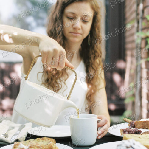 Woman pouring a cup of tea.