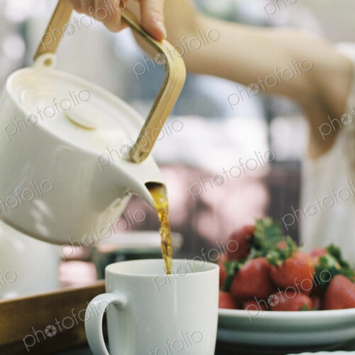 Woman pouring a cup of tea.