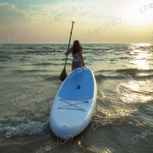 Woman pulling paddleboard in lake Woman pulling paddleboard in lake