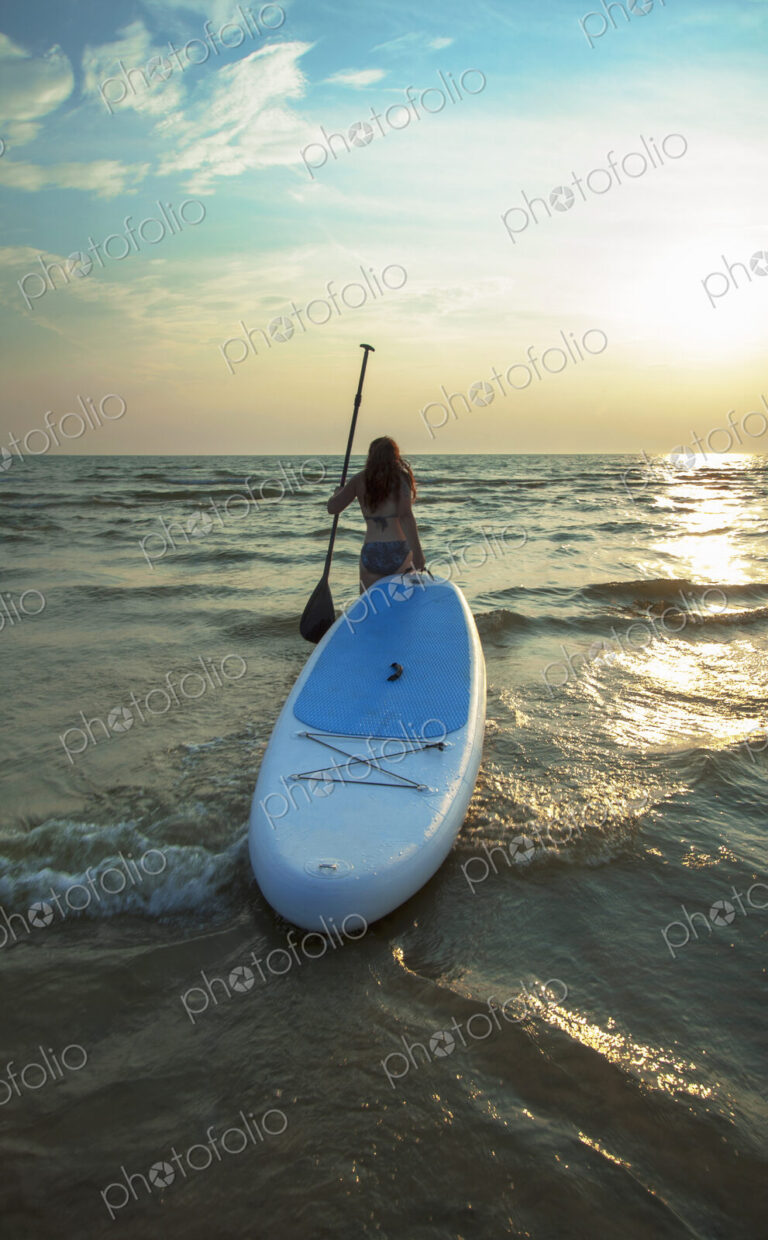 Woman pulling paddleboard in lake