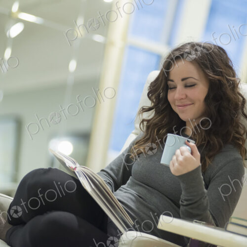 Woman relaxing at home reading with coffee