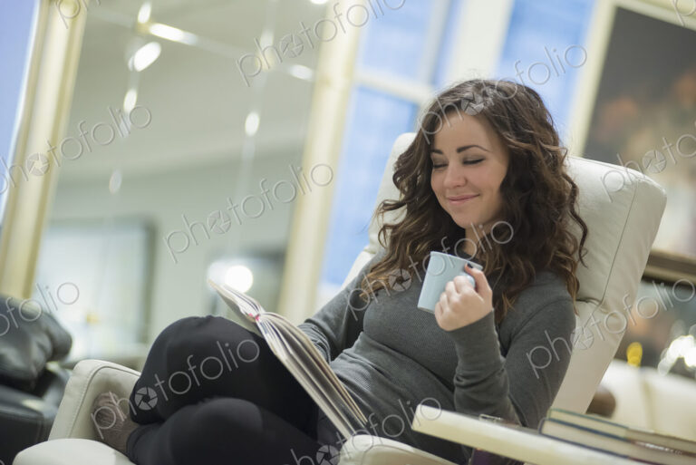 Woman relaxing at home reading with coffee