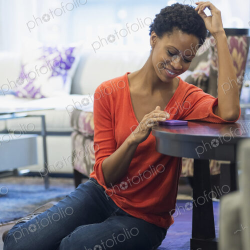 Woman relaxing at home using smartphone