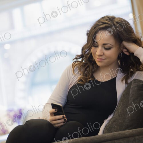 Woman relaxing at home using smartphone