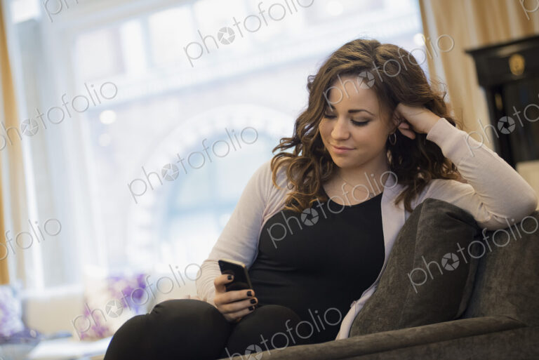 Woman relaxing at home using smartphone