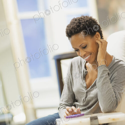 Woman relaxing at home using smartphone
