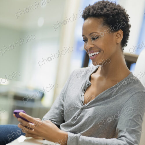 Woman relaxing at home using smartphone