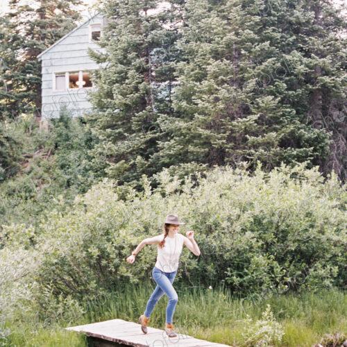 Woman running across a wooden bridge over a stream. Woman running across a wooden bridge over a stream.