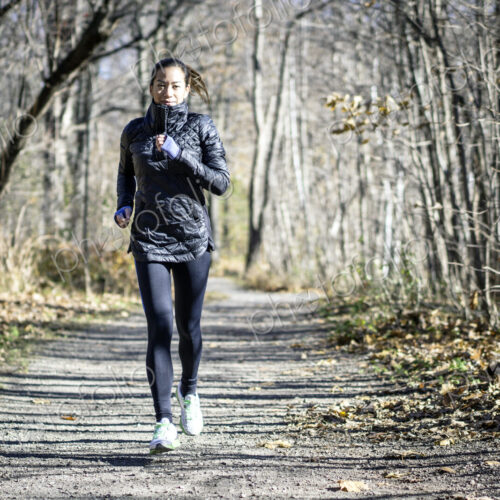 Woman running on dirt path in autumn