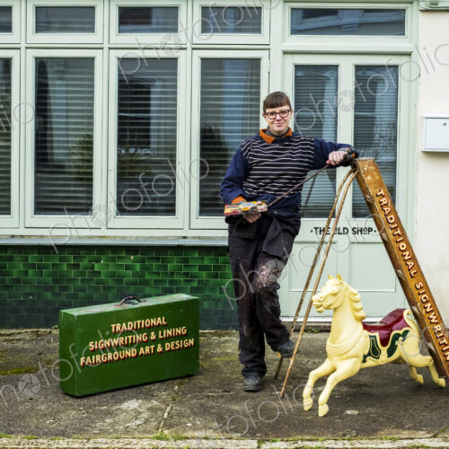 Woman signwriter and craftswoman with a ladder and carousel horse Woman signwriter and craftswoman with a ladder and carousel horse
