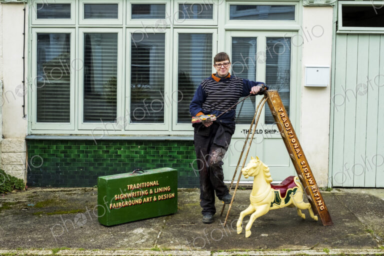 Woman signwriter and craftswoman with a ladder and carousel horse