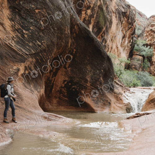 Woman standing by river in a canyon. Woman standing by river in a canyon.