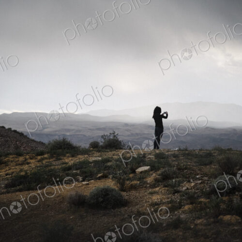 Woman standing in a prairie under a cloudy sky. Woman standing in a prairie under a cloudy sky.