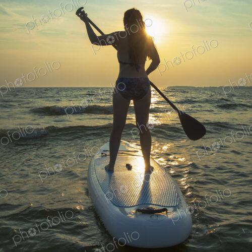 Woman standing on paddleboard in lake