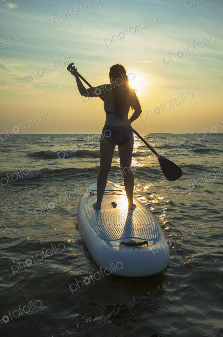 Woman standing on paddleboard in lake