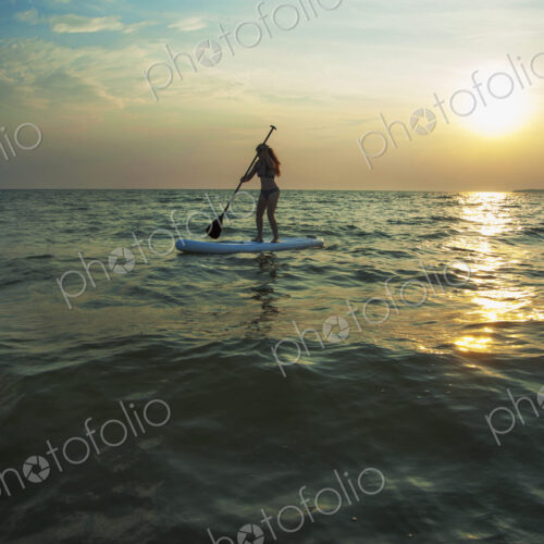 Woman standing on paddleboard in lake