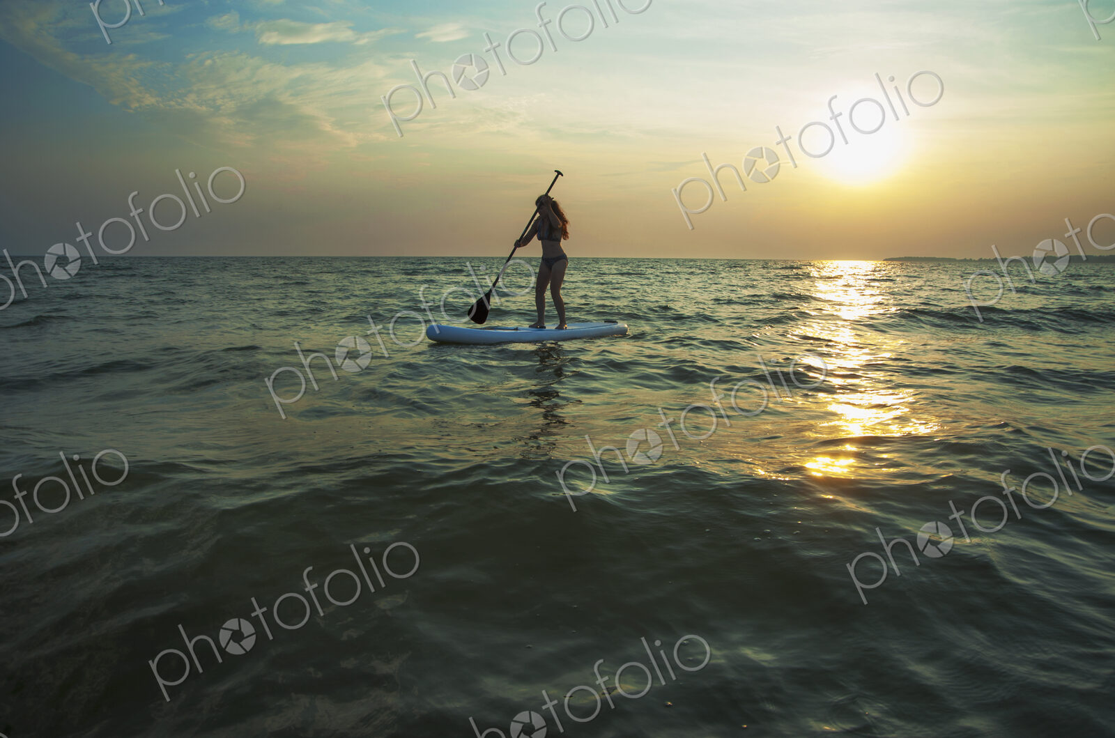 Woman standing on paddleboard in lake