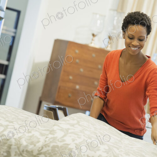 Woman straigtening bed with organic sheeting