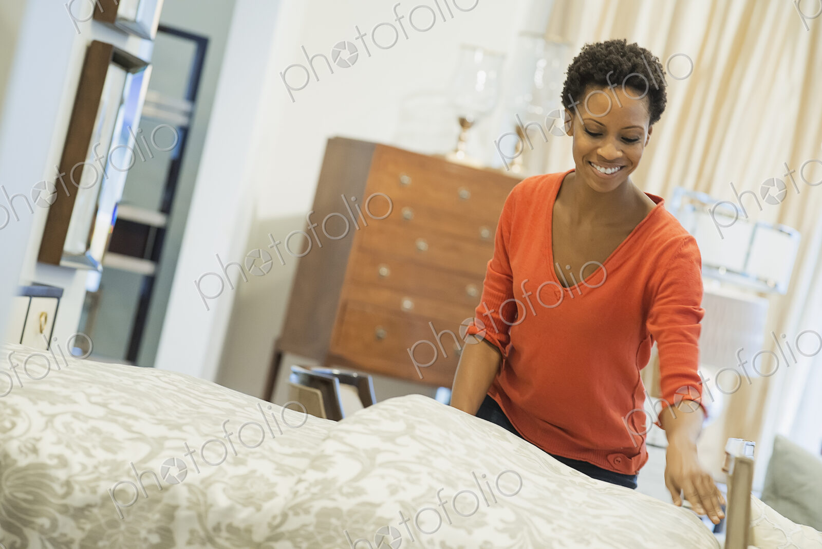Woman straigtening bed with organic sheeting