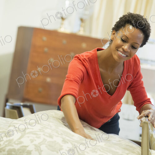 Woman straigtening bed with organic sheeting